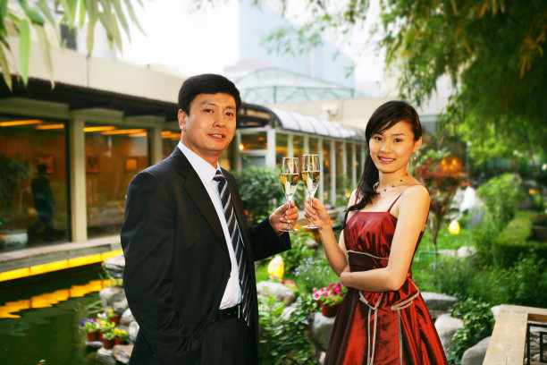 一对男女在酒店阳台里饮酒交谈图片下载