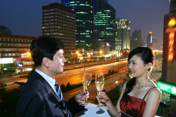 一对男女在都市夜景下饮酒图片下载