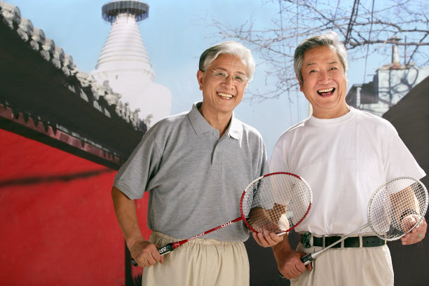 two oriental senior adults playing badminton图片下载