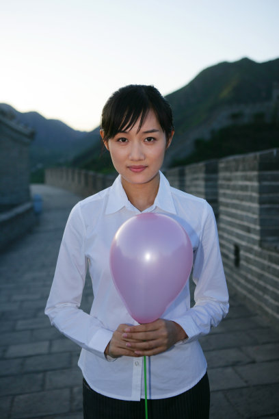 女商务人士在长城上拿着气球图片下载