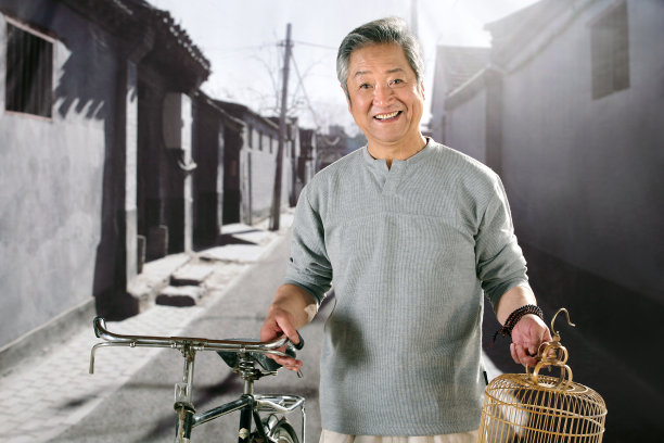 oriental senior adult holding the bicycle图片下载