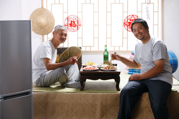 农民父子坐在家中吃饭图片下载