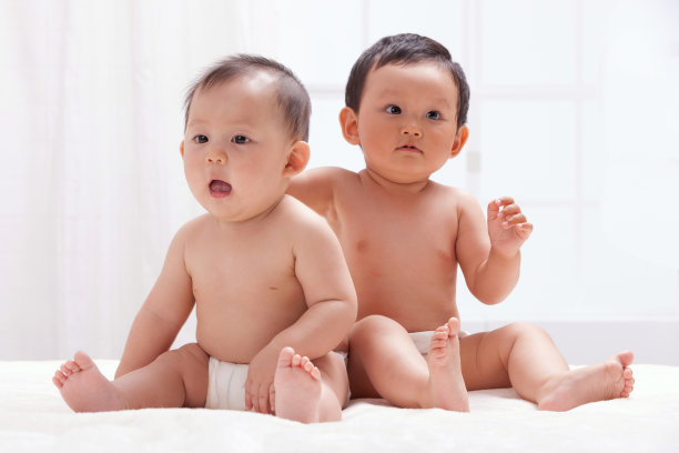 两个婴儿坐在室内床上图片下载