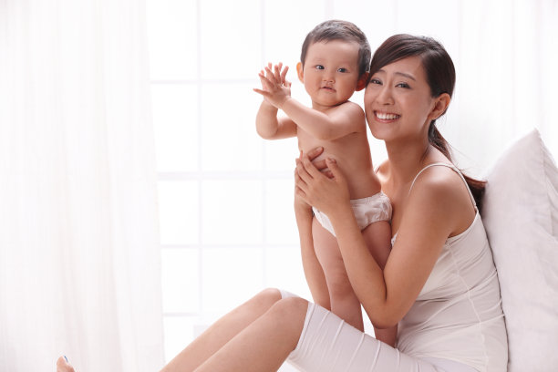 母亲和婴儿坐在床上图片下载