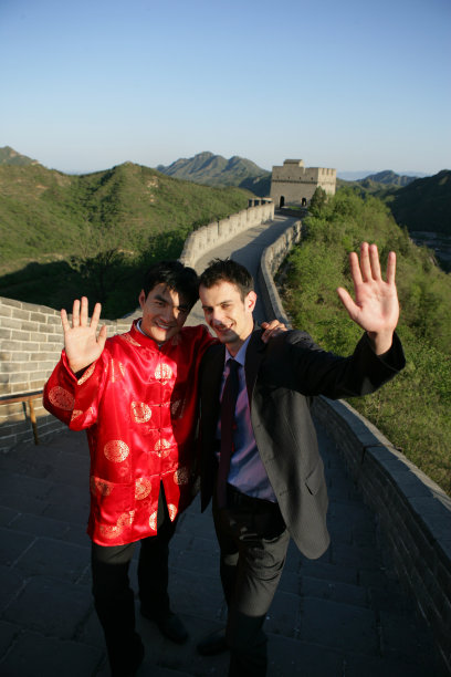 中国传统人士与外国商务人士在长城上站立挥手图片下载