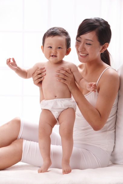 母亲和婴儿坐在床上图片下载