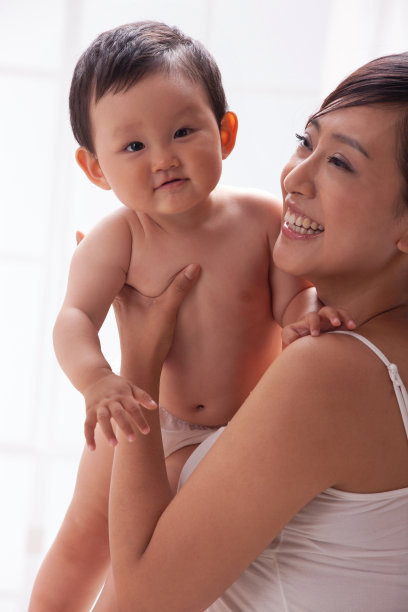 母亲和婴儿坐在床上图片下载