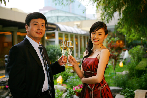 一对男女在酒店阳台饮酒交谈图片下载