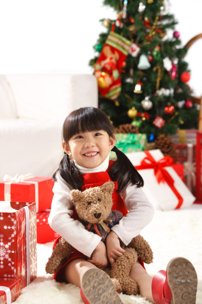 小女孩圣诞节抱着玩具熊图片下载