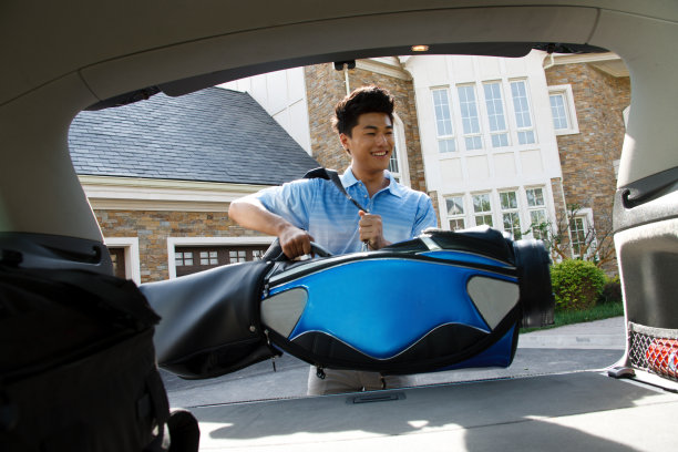 一个青年男人背着高尔夫球包图片下载