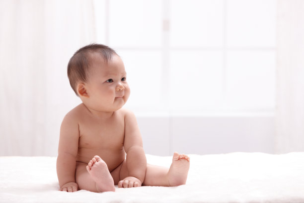 一个婴儿坐在室内床上图片下载