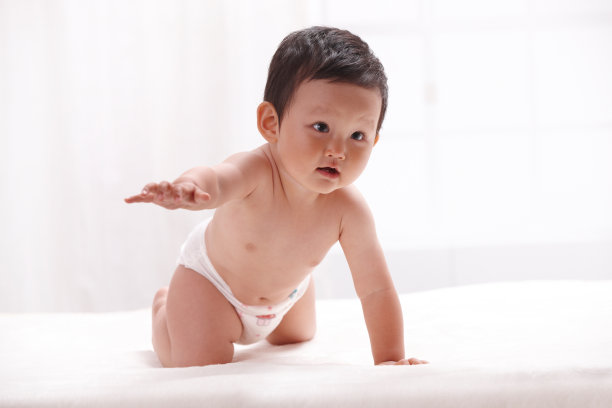 一个婴儿趴在室内床上图片下载