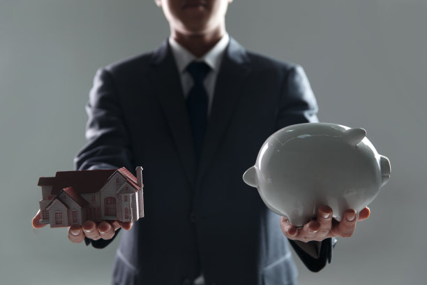 手拿存钱罐及房屋模型图片下载