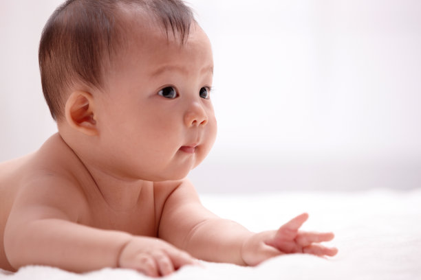 一个婴儿趴在室内床上图片下载