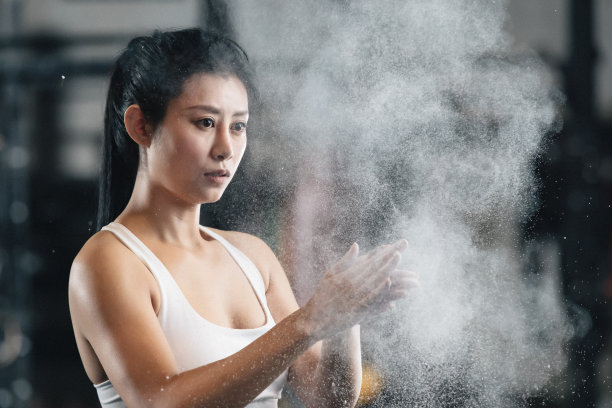 举重运动员往手上涂抹滑石粉图片下载