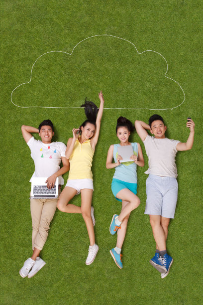 年轻男女躺在草地上看电脑图片下载