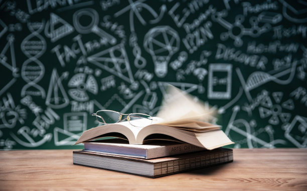 黑板画前的桌子上的书和眼镜图片下载