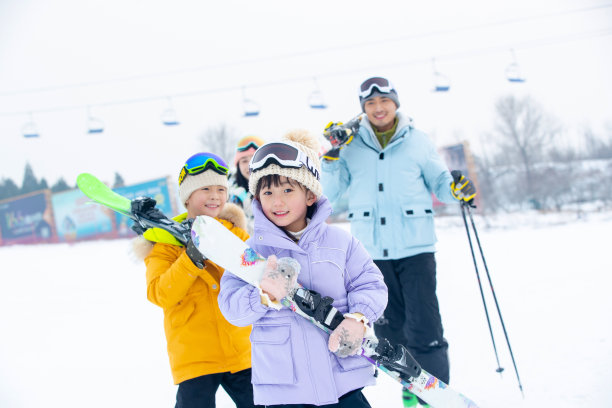 雪场上拿着雪具去滑雪的一家四口图片下载