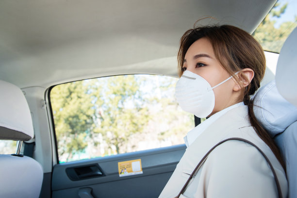 年轻女人戴口罩乘坐汽车图片下载