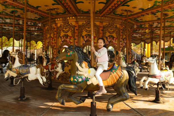 小女孩在玩旋转木马图片下载