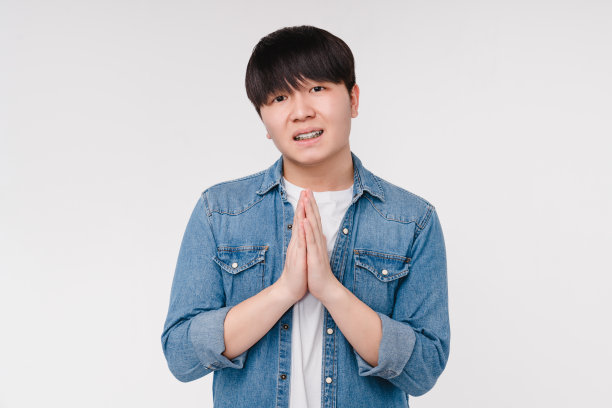 年轻的亚洲韩国男子学生男孩乞求冥想祈祷孤立在白色背景。禅宗般的心情，让人安详图片下载