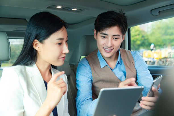 商务人士在汽车里看平板电脑图片下载