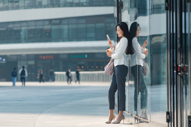 站在户外看手机的商务女性图片下载