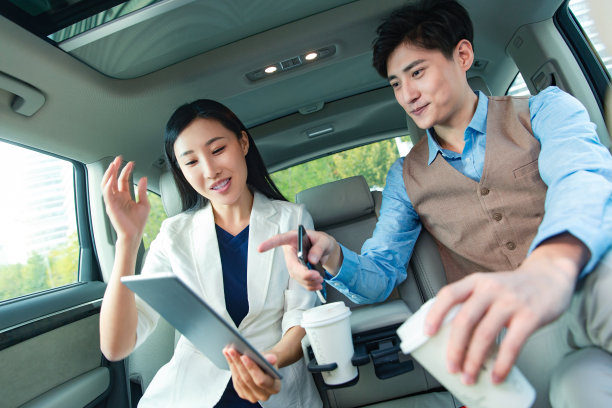 商务人士在汽车里看平板电脑图片下载