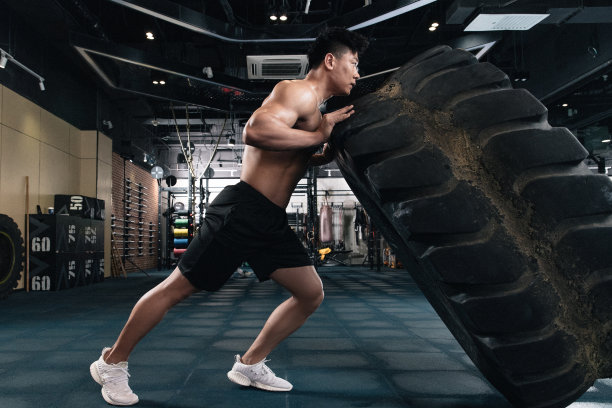 年轻男子在健身房做翻轮胎练习图片下载