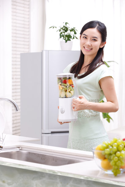 年轻女人在厨房做果汁图片下载