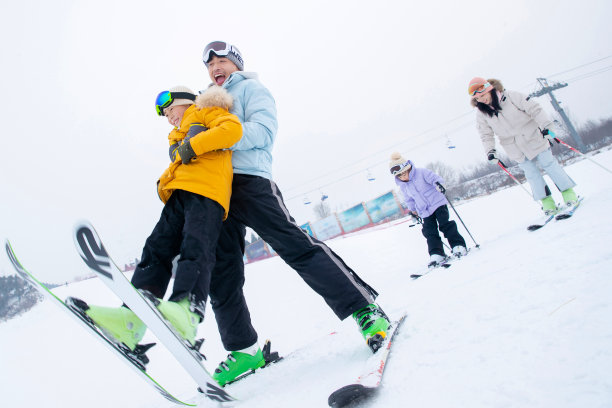 滑雪场内边滑雪边嬉戏的一家四口图片下载