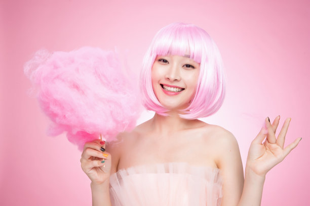 拿着粉色棉花糖的时尚年轻女孩图片下载