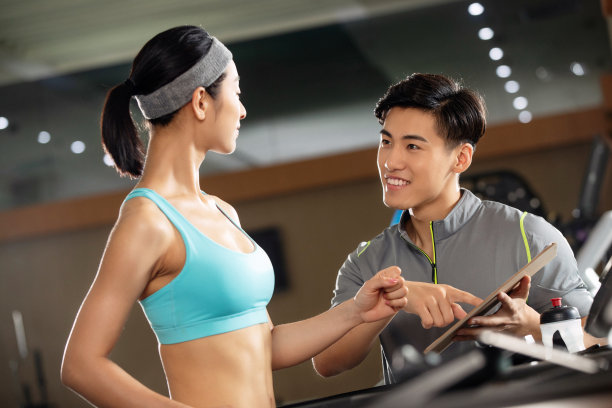 健身教练指导青年女人健身图片下载