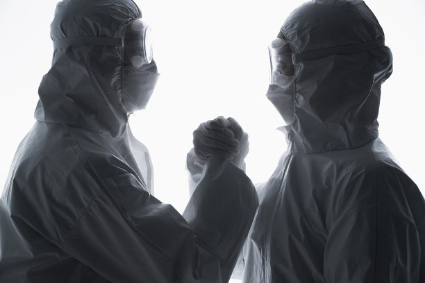 穿防护服的医生相互加油鼓励图片下载