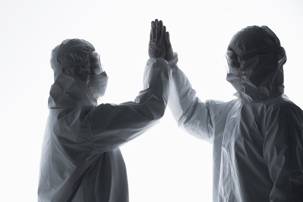 穿防护服的医生相互加油鼓励图片下载