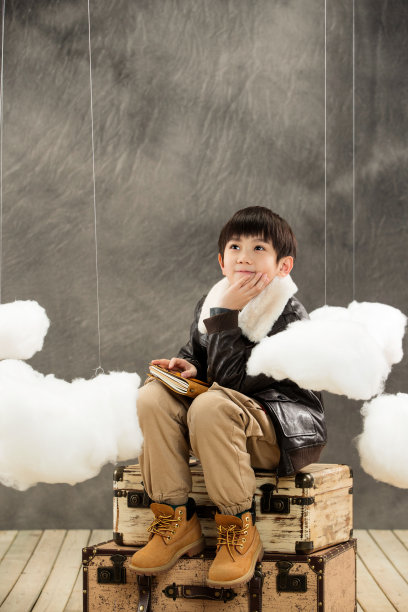 快乐男孩坐在行李箱上幻想图片下载