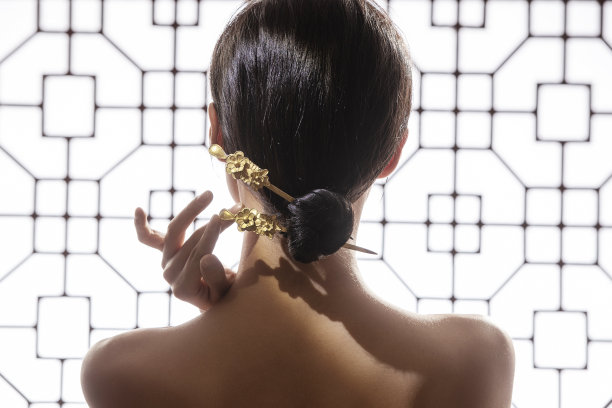 正在调整发髻中簪子的东方女人图片下载