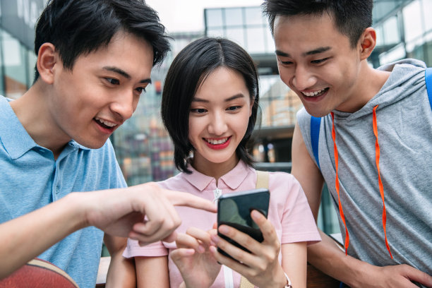 快乐的大学生在户外看手机图片下载