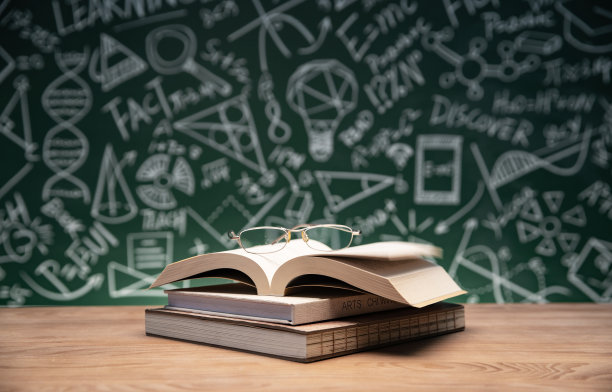 黑板画前的桌子上的书和眼镜图片下载