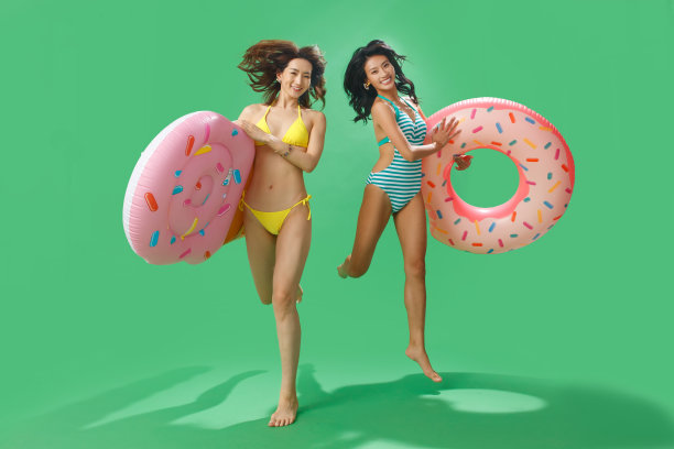 穿比基尼的闺蜜拿着浮排游泳圈图片下载