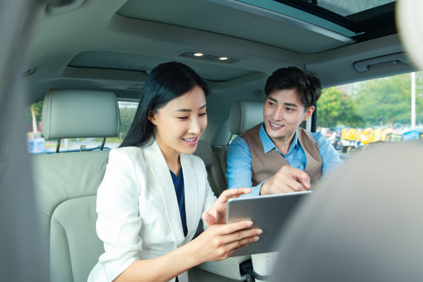 商务人士在汽车里看平板电脑图片下载