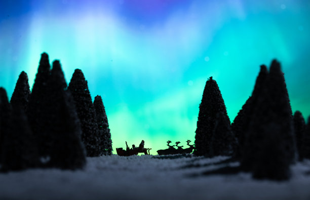 极光下驯鹿拉着雪橇上的圣诞老人图片下载