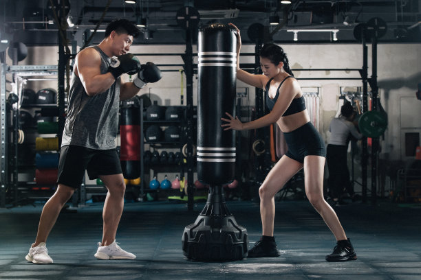 健身房内教练指导年轻男子打拳击图片下载