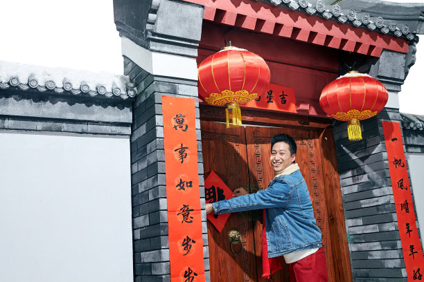 青年男人过年贴春联图片下载