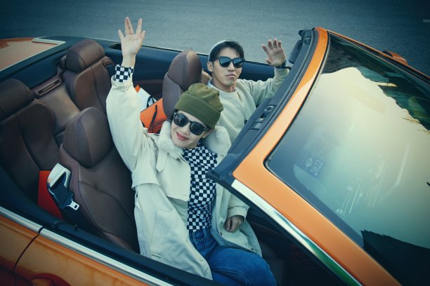 快乐的青年情侣驾驶跑车出行图片下载