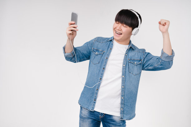 快乐活跃的亚洲韩国青少年跳舞和听音乐播放列表歌曲歌手电台选择音轨在智能手机孤立在白色背景图片下载