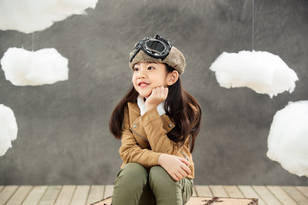 坐在行李箱上的小飞行员图片下载