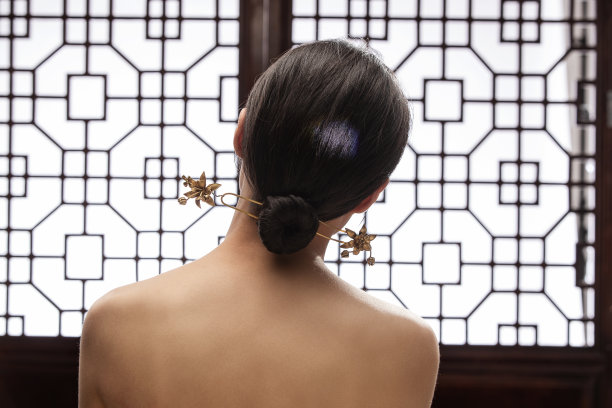 梳着中式发髻歪头的东方女人背影图片下载