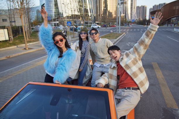 快乐的青年人驾驶跑车出行图片下载