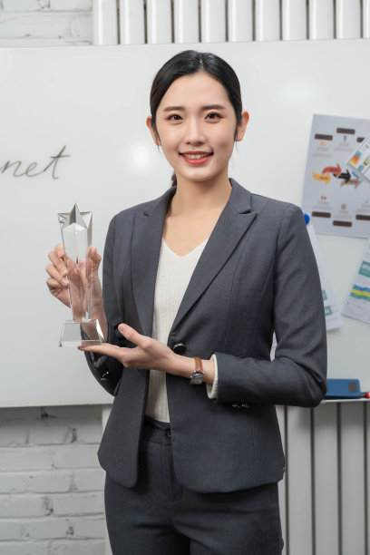 成功的商务女士拿着奖杯图片下载